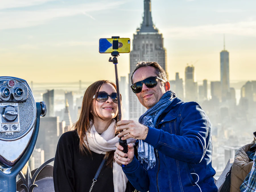 Pareja sonriendo en una selfie frente al Empire State en Nueva York