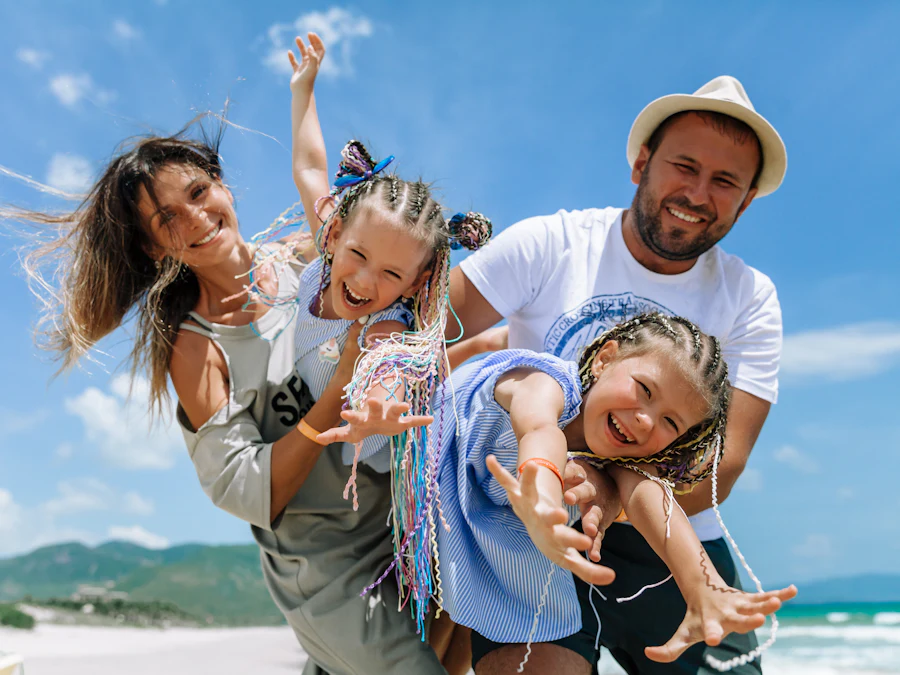 Familia sonriendo de vacaciones en la playa